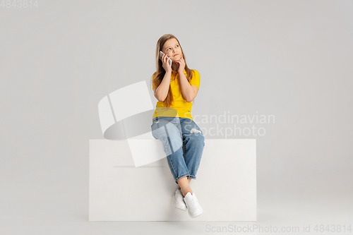 Image of Happy kid, girl isolated on white studio background. Looks happy, cheerful, sincere. Copyspace. Childhood, education, emotions concept