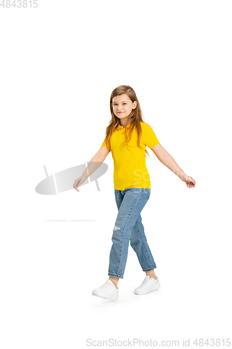 Image of Happy kid, girl isolated on white studio background. Looks happy, cheerful, sincere. Copyspace. Childhood, education, emotions concept