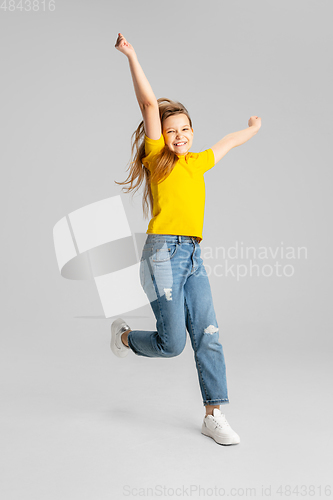 Image of Happy kid, girl isolated on white studio background. Looks happy, cheerful, sincere. Copyspace. Childhood, education, emotions concept