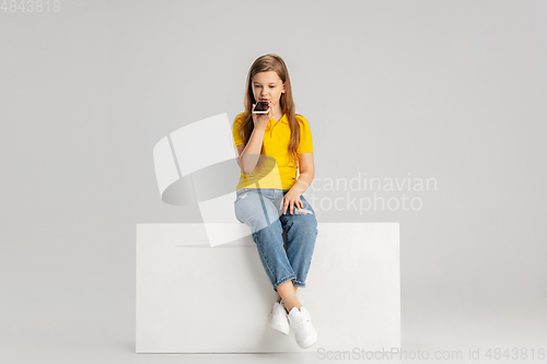 Image of Happy kid, girl isolated on white studio background. Looks happy, cheerful, sincere. Copyspace. Childhood, education, emotions concept