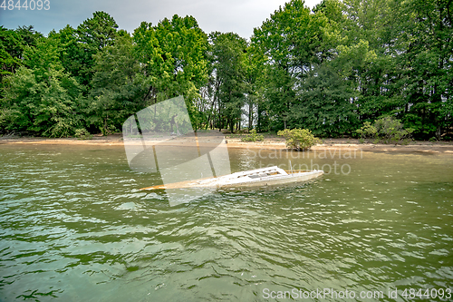 Image of dirty sunken boat floating in the lake