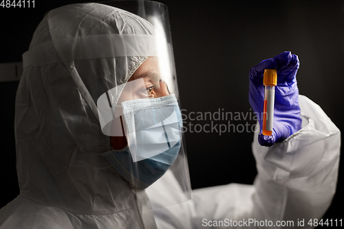 Image of scientist in mask and face shield with test tube