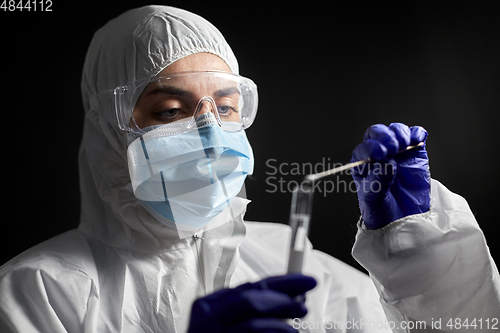 Image of scientist holding beaker with coronavirus test