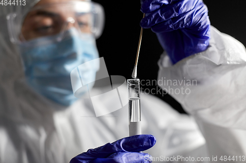 Image of scientist holding beaker with coronavirus test