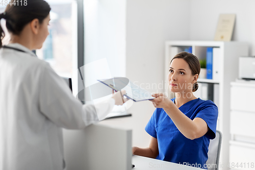 Image of doctor and nurse with clipboard at hospital