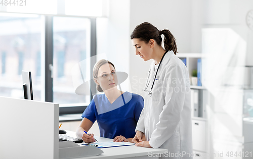 Image of doctor and nurse with clipboard at hospital