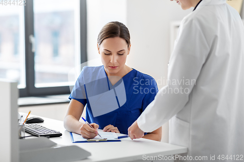 Image of doctor and nurse with clipboard at hospital