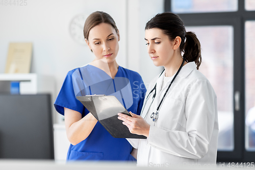 Image of doctor and nurse with clipboard at hospital