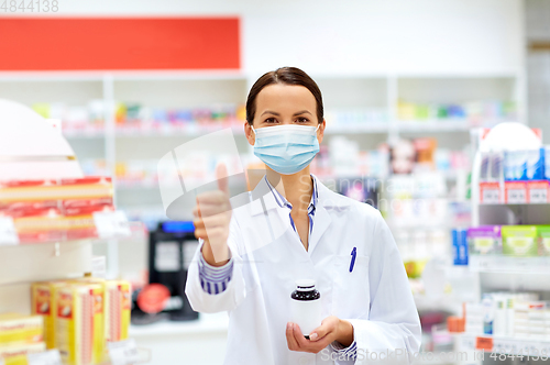 Image of apothecary in mask showing thumbs up at pharmacy