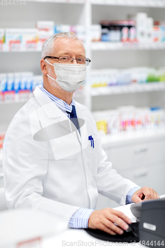 Image of senior apothecary in mask at pharmacy