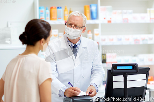 Image of senior apothecary in mask and customer at pharmacy