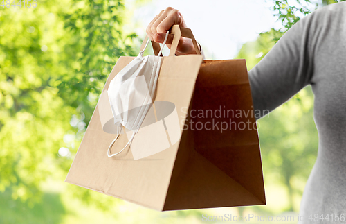 Image of woman with shopping bag, face mask and gloves