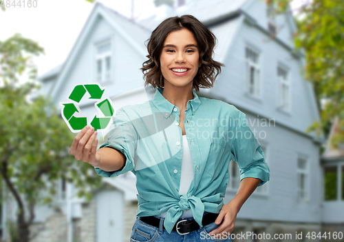 Image of smiling young woman holding green recycling sign