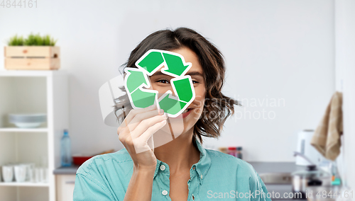 Image of smiling woman looking through green recycling sign