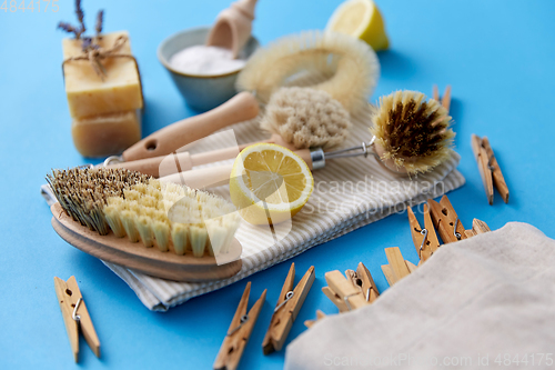 Image of cleaning brushes, lemon and wooden clothespins