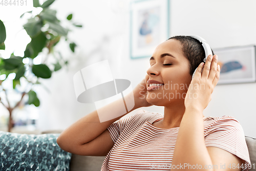 Image of woman in headphones listening to music at home