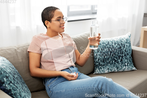 Image of african american woman with water in glass bottle