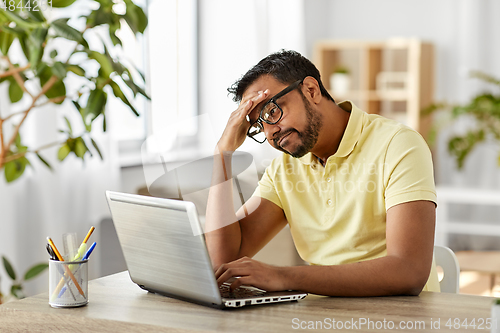 Image of bored man with laptop working at home office