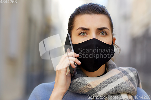 Image of woman in protective reusable mask calling on phone