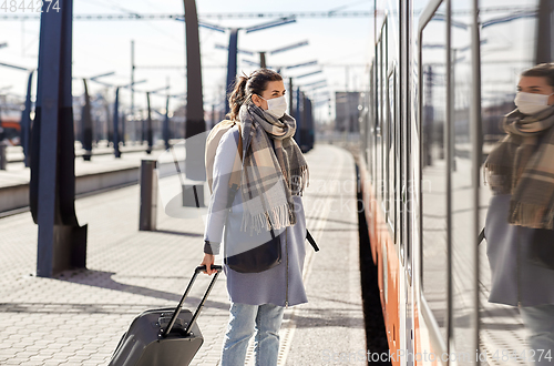 Image of woman in protective face mask at railway station