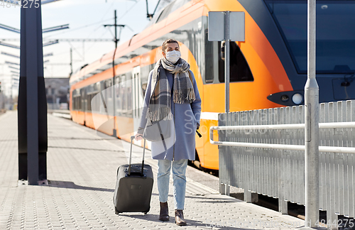 Image of woman in protective face mask at railway station