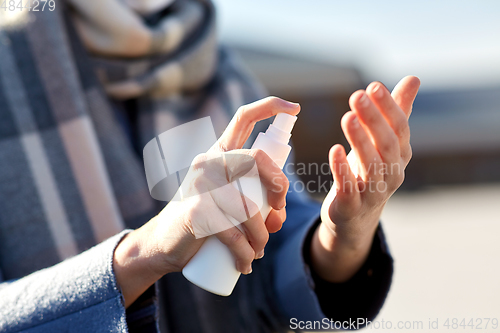 Image of close up of woman spraying hand sanitizer