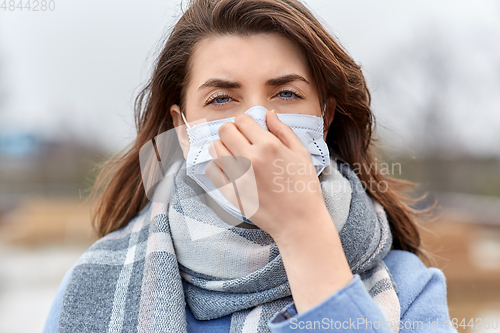 Image of young woman wearing protective medical mask