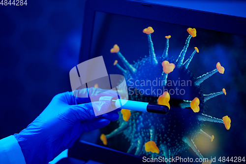 Image of hand holding beaker with coronavirus blood test