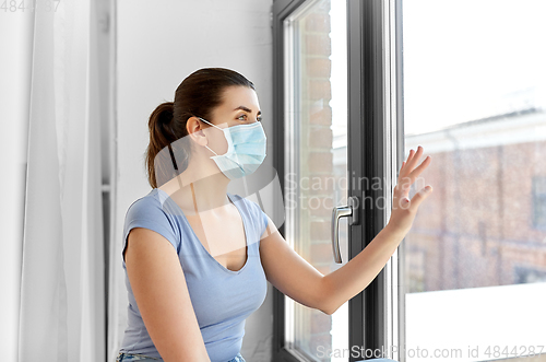 Image of sick young woman wearing protective medical mask