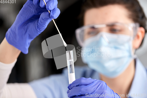 Image of doctor holding beaker with coronavirus test