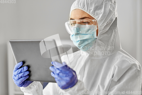 Image of doctor in protective wear with tablet computer