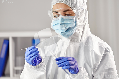 Image of scientist holding beaker with coronavirus test