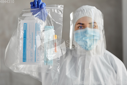 Image of doctor in protective wear with medical test sample