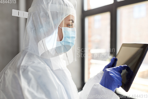 Image of doctor in protective wear with tablet computer