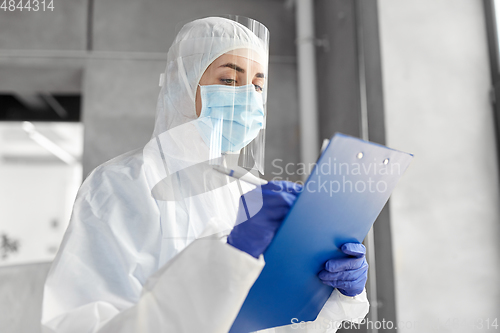 Image of doctor in medical mask and shield with clipboard