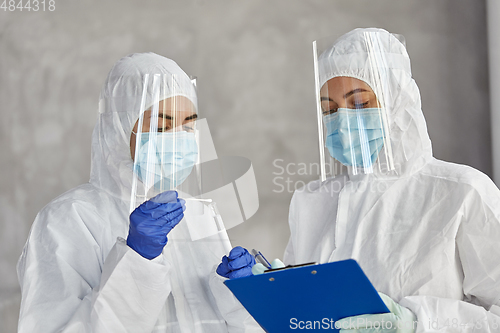 Image of doctors in medical mask and shield with clipboard