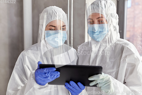 Image of doctors in protective wear with tablet computer
