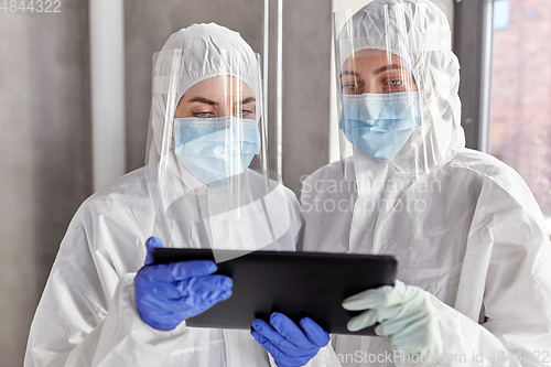 Image of doctors in protective wear with tablet computer