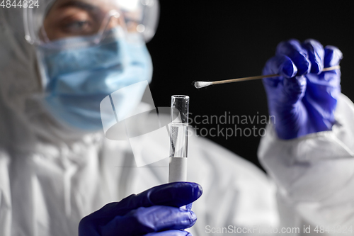 Image of scientist holding beaker with coronavirus test