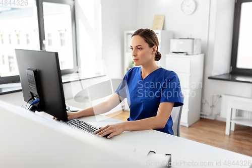 Image of doctor or nurse with computer working at hospital