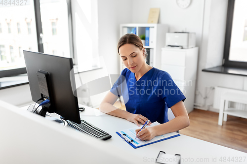 Image of doctor or nurse with clipboard working at hospital