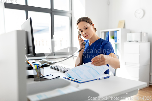 Image of doctor with computer calling on phone at hospital