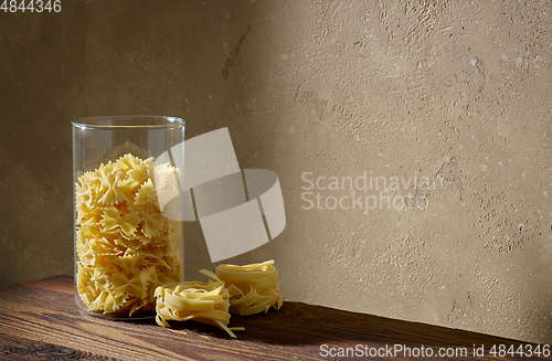 Image of various pasta on brown wooden shelf