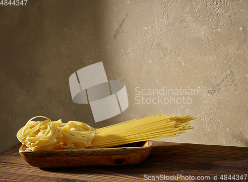 Image of various pasta on brown wooden shelf