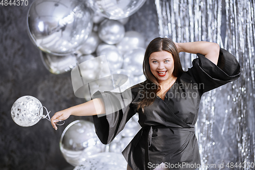 Image of Happy plus size woman dancing at the party