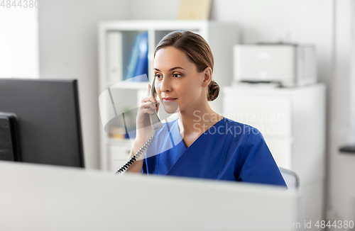 Image of doctor with computer calling on phone at hospital