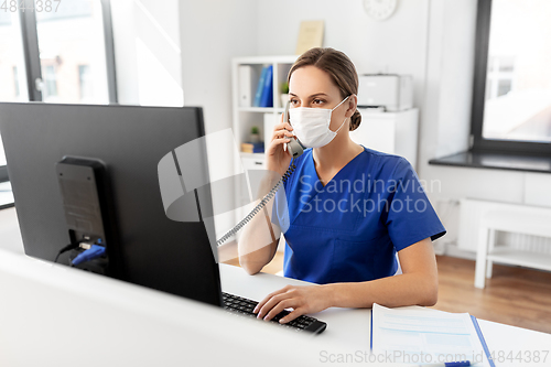 Image of doctor with computer calling on phone at hospital