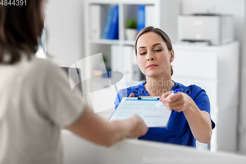 Image of doctor with clipboard and patient at hospital