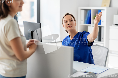 Image of doctor showing something to patient at hospital