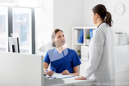 Image of doctor and nurse with clipboard at hospital